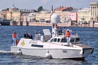 Russian president Vladimir Putin, third from left, stands aboard the Raptor boat during his visit to St Petersburg on Navy Day